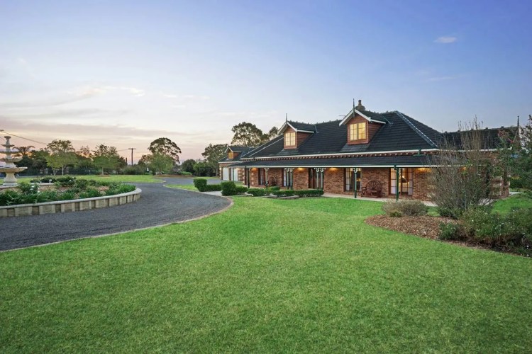 A house with a driveway and grass in front of it. A house with a driveway and grass in front of it.